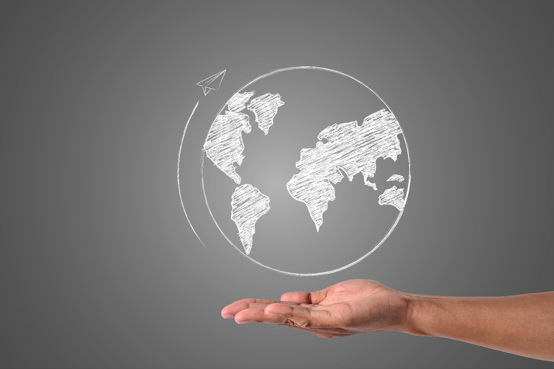 Globe dessiné à la craie posé sur une main, symbolisant le développement international TradeNexia